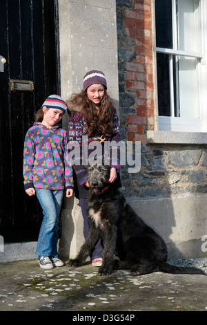 Ragazze con Irish Wolfhound al di fuori di una zona rurale cottage in Irlanda Foto Stock