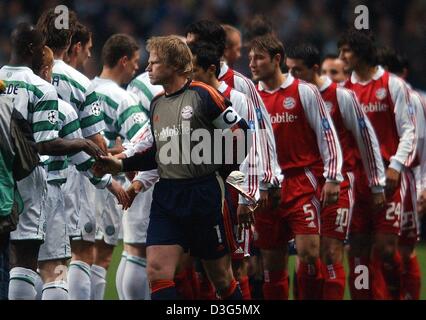 (Dpa) - Bayern il capitano di una squadra e il portiere Oliver KAHN anteriore (R) conduce il Bayern team per agitare le mani con il Glasgow giocatori prima della Champions League Soccer Game contrapposta Bayern Monaco di Baviera e il Celtic Glasgow, a Glasgow in Scozia, 25 novembre 2003. La partita si è conclusa in un 0-0. Foto Stock