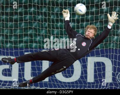 (Dpa) - Bayern Monaco di Baviera portiere Oliver KAHN immersioni per effettuare un salvataggio durante un corso di formazione del FC Bayern Monaco di Baviera a Glasgow, Scozia, 24 novembre 2003. Il Bayern Monaco giocherà Celtic Glasgow nel gruppo gioco della Champions League su Martedì, 25 novembre 2003. Foto Stock