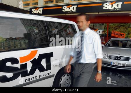 (Dpa) file - un uomo cammina attraverso il parco auto passato un auto a noleggio dell'agenzia noleggio auto Sixt AG a Monaco di Baviera, Germania, il 20 agosto 2002. La società ha annunciato il 18 novembre 2003 che tthey consentirebbe di aumentare i loro profitti per Outlook 2003 dopo i risultati positivi nel terzo trimestre del corrente anno di attività. Sixt ha anche annunciato che il margine lordo di guadagno aumenterà del 10 percento. Foto Stock