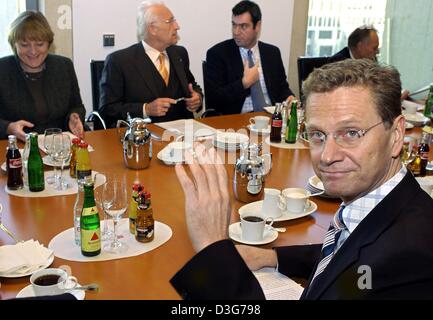 (Dpa) - Guido Westerwelle (R), presidente del partito liberale FDP onde durante una riunione a Berlino, 12 novembre 2003. Opposto di Westerwelle seduta sono Angela Merkel (L), presidentessa del partito democratico cristiano CDU e Edmund Stoiber (C), Presidente della CSU, il conservatore partito fratello della CDU. I leader dei partiti di opposizione si sono incontrati per discutere la prossima imposta e soc Foto Stock