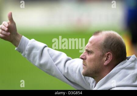 (Dpa) - Thomas Schaaf, il pullman della Bundesliga tedesca club di calcio SV Werder Bremen, dà il pollice in alto segno durante il decimo turno Bundesliga soccer game di SV Werder Bremen contro SC di Friburgo, in Germania, il 25 ottobre 2003. Brema vince la partita 4-2 e si sposta fino al terzo posto in tedesco prima divisione. Foto Stock