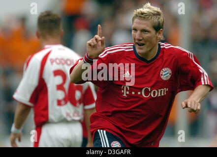 (Dpa) - del Bayern Monaco giocatore Sebastian Schweinsteiger cheers e gesti dopo il punteggio vincendo 2-1 obiettivo, mentre la Colonia Lukas Podolski ruba la scena durante la Bundesliga gioco 1 contrapposte FC Colonia e Bayern Monaco di Baviera a Colonia, Germania, 1 maggio 2004. Il Bayern Monaco ha vinto 2-1. Foto Stock