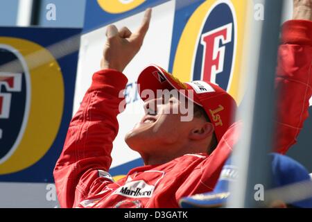 (Dpa) - Michael Schumacher (Team Ferrari) festeggia sul podio dopo la vittoria del 2004 Gran Premio di San Marino di Imola, Italia, 25 aprile 2004. Foto Stock