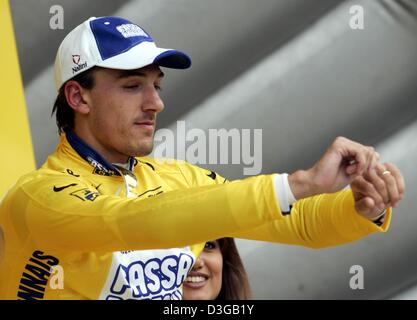 (Dpa) - Swiss Fabian Cancellara del team Fassa Bortolo mette sul leader della corsa la maglia gialla dopo la prima tappa del Tour de France a Charleroi (Belgio), 4 luglio 2004. 23-anno-vecchio Cancellara ha fatto vincere anche il prologo del Tour de France il giorno prima. La prima e la 202.5km lunga tappa del 91Tour de France corsa di ciclismo ha preso i ciclisti da Liege a Charleroi. Foto Stock