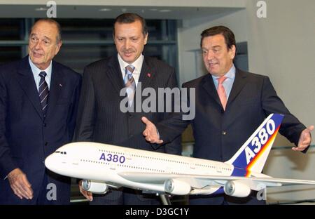 (Dpa) - Il cancelliere tedesco Gerhard Schroeder (R), il primo ministro turco Recep Tayyip Erdogan (C) e il presidente francese Jacques Chirac a stare dietro un modello Airbus a Berlino, Germania, 26 ottobre 2004. I leader hanno partecipato ad una cerimonia di firma per un annunciato in precedenza 2,8 miliardi di euro la vendita di 36 Airbus getti per la Turchia la compagnia di stato, Turkish Airlines. Foto Stock