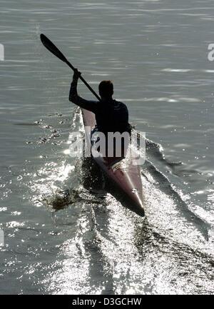 (Dpa) - Un uomo in kayak sul lago Alster è visto contro la luce ad Amburgo, 3 ottobre 2004. Foto Stock