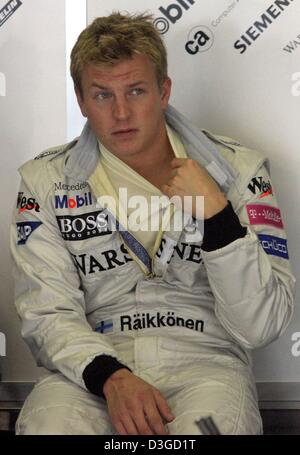 (Dpa) - Finlandese pilota di Formula Uno Kimi Raeikkoenen siede nel suo team di zona pit a Suzuka International Racing Course a Suzuka, in Giappone, 8 ottobre 2004. A causa di un avvicinamento typhoon, racing potrebbe essere annullato il sabato. Il Gran Premio del Giappone si svolgerà domenica 10 ottobre 2004. Foto Stock
