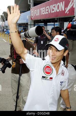 (Dpa) - Giapponese pilota di Formula Uno di Takuma Sato (BAR-Honda) arriva presso il paddock del circuito di gara a Suzuka, in Giappone, 7 ottobre 2004. Il giapponese di FORMULA ONE Grand Prix sarà in corso la domenica, 10 ottobre 2004. Foto Stock