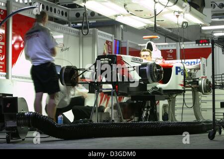 (Dpa) - lavori di meccanica su di una vettura da corsa alla Toyota pit sulla nuova Shanghai International Circuit in Cina a Shanghai, 24 settembre 2004. Foto Stock