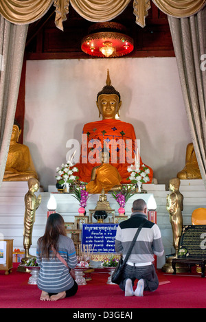 Due adoratori pregare prima di una statua del Buddha al Wat Nam Hoo nella valle di Pai, Mae Hong Son provincia, Thailandia Foto Stock