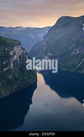 Massiccio, alte scogliere e cascate al tramonto nel famoso Fiordo di Geiranger in Norvegia Foto Stock