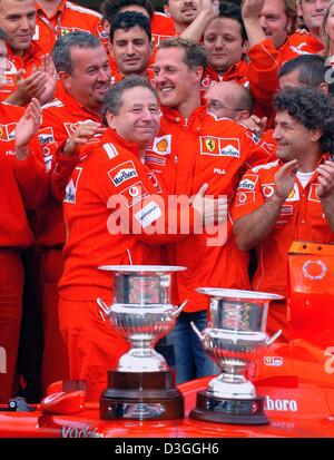 (Dpa) - Tedesco Ferrari driver di Formula Uno Michael Schumacher (C) festeggia insieme a testa Ferrari Jean Todt (L) e il resto della squadra dopo il belga di FORMULA ONE Grand Prix in Spa, 29 agosto 2004. Schumacher ha terminato al secondo posto nel Grand Prix, graffatura di un inedito settimo titolo mondiale nonostante non vincere solo per la seconda volta in 14 gare di questo mare Foto Stock