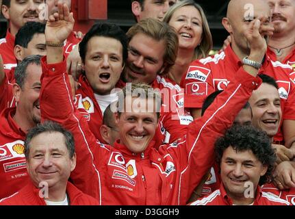 (Dpa) - Tedesco Ferrari driver di Formula Uno Michael Schumacher (C) festeggia con testa Ferrari Jean Todt (L) e il resto della sua squadra dopo il belga di FORMULA ONE Grand Prix in Spa, 29 agosto 2004. Schumacher ha terminato al secondo posto nel Grand Prix, graffatura di un inedito settimo titolo mondiale nonostante non vincere solo per la seconda volta in 14 gare in questa stagione. Foto Stock