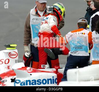 (Dpa) - Australian pilota di Formula Uno Ryan Briscoe (Toyota) ottiene fuori la sua vettura dopo un incidente nell'Eau Rouge curva durante la seconda traiing su formula one racing pista di Spa Francorchamps, Belgio, Venerdì, 27 agosto 2004. Il driver non è stato ferito. Il Gran Premio del Belgio si terrà nella Spa di Domenica, 29 agosto 2004. Foto Stock