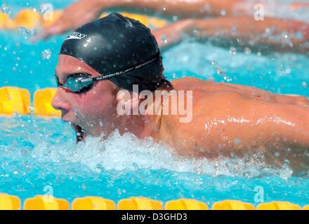 (Dpa) - US nuotatore e detentore del record mondiale di Ian Crocker opere il suo modo attraverso l'acqua al clock più veloce tempo complessivo in uomini 100m Butterfly manches di qualificazione all'Olympic Aquatic Centre a Atene, Grecia, 19 agosto 2004. Foto Stock