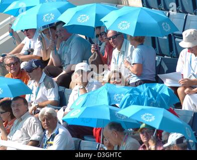 (Dpa) - spettatori protegge da essi stessi lo sfolgorante sole di mezzogiorno con ombrelloni durante il nuoto manches di qualificazione al Athens Olympic Aquatic Centre durante i Giochi Olimpici di Atene, Grecia, 15 agosto 2004. Foto Stock