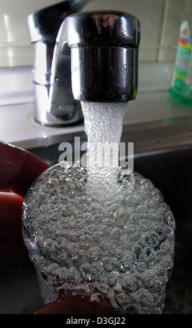 (Dpa) - flussi di acqua da un rubinetto in un bicchiere, raffigurato in una casa a Francoforte in Germania, 9 agosto 2004. Foto Stock