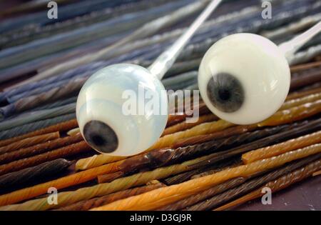 (Dpa) - Due non ancora finito di bulbi oculari in vetro giacciono su vetro colorato aderisce a Augenprothetik Lauscha protesi oculari costruttore in Lauscha, Germania, 3 agosto 2004. Il vetro colorato bastoncini sono utilizzate per la replica dell'iride sul vetro bulbi oculari. Vetro artificiale occhi avevano inventato e prodotto per la prima volta nel 1835 da Ludwig Mueller-Uri in Lauscha, Germania orientale. Gli occhi sono prod Foto Stock