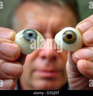 (Dpa) - Ocularist Andreas Mueller-Uri mostra due vetro finito bulbi oculari a Augenprothetik Lauscha protesi oculari costruttore in Lauscha, Germania, 3 agosto 2004. Vetro artificiale occhi avevano inventato e prodotto per la prima volta nel 1835 da Ludwig Mueller-Uri in Lauscha, Germania orientale. Gli occhi sono prodotte dal cosiddetto vetro Kryolt, che è fuso nelle vetrerie di Lauscha. Esso prende ab Foto Stock