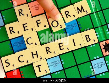 (Dpa) - un dito si muove la lettera 'o' in posizione per formare la parola 'Rechtschreibreform' (riforma ortografica) su una scheda di Scrabble, a Schwerin (Germania), 9 agosto 2004. Burocrati del governo e gli allievi sono tenuti ad adottare la nuova ortografia il prossimo anno con la fine di un periodo di transizione che è iniziato nel 1998. Ma i grandi editori di notizie che sono diminuiti in linea con i cambiamenti di cinque anni fa, hanno Foto Stock