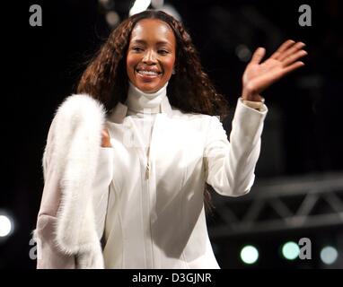 (Dpa) - British super model Naomi Campbell sorrisi e le onde la sua mano come lei cammina sulla passerella durante un open-air fashion show presentando la corrente in autunno e in inverno la moda a Duesseldorf in Germania, 31 luglio 2004. La passerella è lungo 700 metri e secondo gli organizzatori la passerella più lunga del mondo. Circa 250.000 spettatori hanno partecipato alla mostra. Foto Stock