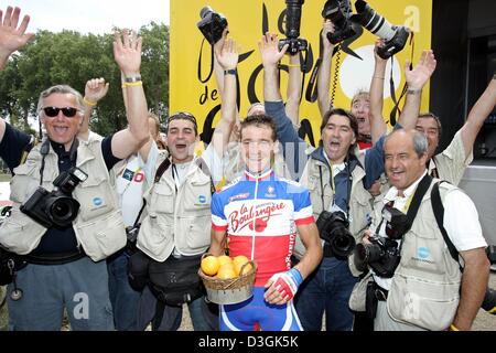 (Dpa) - ciclista francese Thomas Voeckler del team Brioches La Boulangere (C) pone con i fotografi che hanno aggiudicato Voeckler Prix d'arancia', prima della ventesima fase del 2004 Tour de France corsa di ciclismo in Montereau, Francia, 25 luglio 2004. Il tradizionale premio d'arancio è aggiudicato da fotografi che copre il Tour da motorcyles al più fotogenica e più belle ciclista di di Foto Stock