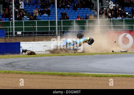 (Dpa) - Italiano pilota di Formula Uno Jarno Trulli della Renault F1 va in crash con la sua vettura da corsa contro la barriera del circuito di gara a Silverstone, Regno Unito, 11 luglio 2004. Trulli ha ottenuto al di fuori della sua vettura illeso. Foto Stock