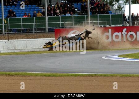 (Dpa) - Italiano pilota di Formula Uno Jarno Trulli della Renault F1 va in crash con la sua vettura da corsa contro la barriera del circuito di gara a Silverstone, Regno Unito, 11 luglio 2004. Trulli ha ottenuto al di fuori della sua vettura illeso. Foto Stock