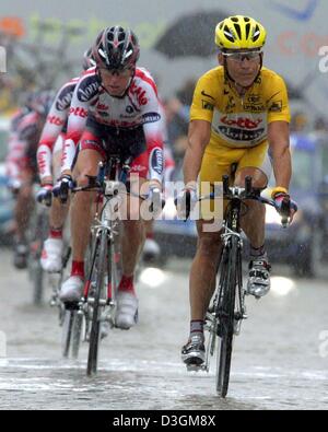 (Dpa) - Team Lotto-Domo, guidato dal ciclista australiano Robbie McEwen chi indossa la maglia gialla del leader globale, corse durante il 64,5 km lungo la quarta tappa del Tour de France da Cambrai per Arras, Francia, 7 luglio 2004. Forti piogge in tutta la fase causato molti incidenti e difetti. Dopo che il suo team fnished in un deludente 18esimo posto McEwen ha perso la maglia gialla dopo il Foto Stock