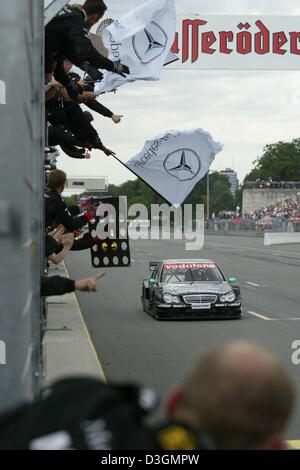 (Dpa) - Ventilatori allietare come il britannico pilota DTM Gary Paffett manzi la sua AMG-Mercedes Classe C verso la linea di finitura sul Norisring racetrack durante il tedesco Touringcar Masters campionati (DTM) in Nuremberg, Germania, 27 giugno 2004. 22-anno-vecchio Paffett è riuscito ad affermare se stesso contro i suoi concorrenti nella quinta gara del DTM e ha vinto su 2.300 km lungo Via dopo 72 round Foto Stock