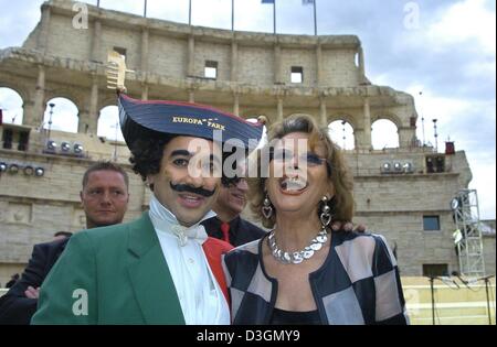 (Dpa) - Italiano attrice Claudia Cardinale sorrisi come lei pone con un mime imitando Charles Chaplin davanti a uno sfondo del Colosseo a Roma per l apertura delle celebrazioni per il nuovo "Colosseo" hotel all'Europa-Park parco divertimenti di Rust, Germania, 24 giugno 2004. Foto Stock