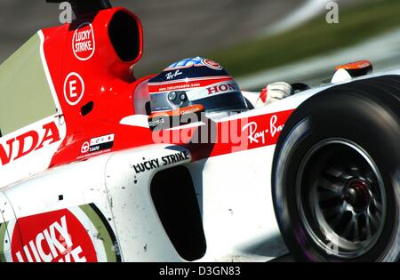 (Dpa) - Giapponese pilota di Formula Uno di Takuma Sato di BAR Honda manzi alla sua formula one racing car attraverso una curva ad S durante il corso di formazione gratuito sulla pista di Indianapolis, Stati Uniti d'America, 19 giugno 2004. Foto Stock