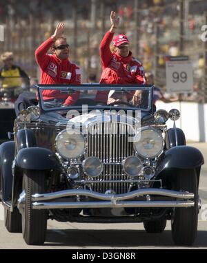 (Dpa) - Le due Ferrari di Formula Uno pilota tedesco Michael Schumacher (R) e il brasiliano Rubens Barrichello wave le loro mani come si siedono in un'auto d'epoca durante il tradizionale drivers' parade prima dello start del Gran Premio degli Stati Uniti sulla pista di Indianapolis, Stati Uniti d'America, 20 giugno 2004. Foto Stock