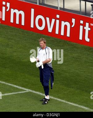 (Dpa) - portiere tedesco Oliver KAHN sorge sul passo di fronte a uno slogan pubblicitario che recita "sto lovin" durante la sessione di allenamento della nazionale tedesca di calcio a Porto, Portogallo, 14 giugno 2004. Il team tedesco ha preparato per l'Euro 2004 soccer game opponendosi alla Paesi Bassi su Martedì, 15 giugno 2004. Foto Stock