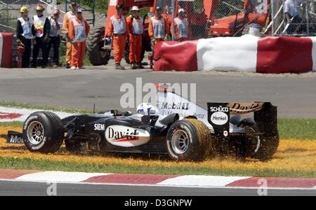 (Dpa) - Scottish pilota di Formula Uno David Coulthard (McLaren Mercedes) guidare la sua vettura da corsa attraverso un cerotto di erba dopo una collisione all'inizio del Gran Premio del Canada a Montreal, Canada, 13 giugno 2004.