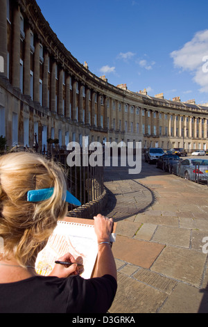 Una signora artista abbozzare davanti al Royal Crescent, Bath, Regno Unito Foto Stock