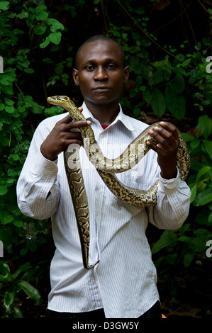 L'uomo tenendo un python, Villaggio Mamba, Mombasa, in Kenya Foto Stock