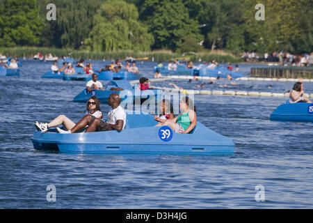 Amici godere di gite in barca sul lago a serpentina in Hyde Park Londra Foto Stock