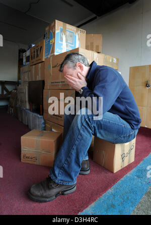 Uomo con testa in mani con la pila di scatole di rimozione casa nuovamente spostare in possesso di senzatetto HOME SFRATTO LO STRESS di rilocazione REGNO UNITO Foto Stock