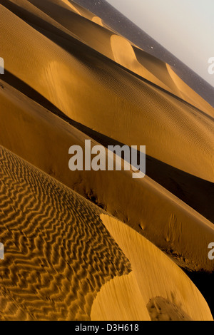 A tarda notte sole risplende attraverso le dune di sabbia di Gran Canaria in Playa Del Ingles area della destinazione di vacanza isola Foto Stock