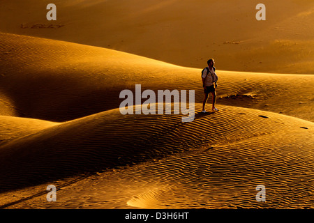 A tarda notte sole risplende attraverso le dune di sabbia di Gran Canaria in Playa Del Ingles area della destinazione di vacanza isola Foto Stock