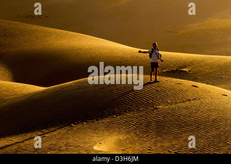 A tarda notte sole risplende attraverso le dune di sabbia di Gran Canaria in Playa Del Ingles area della destinazione di vacanza isola Foto Stock