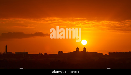 Faro di Maspalomas (sinistra) e il centro della città si stagliano nella tarda sera sun come si imposta su Gran Canaria Foto Stock