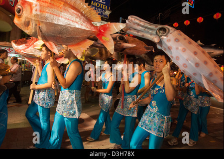 Ragazzi che trasportano sovradimensionare i frutti di mare durante una parata di Keelung, Taiwan Foto Stock