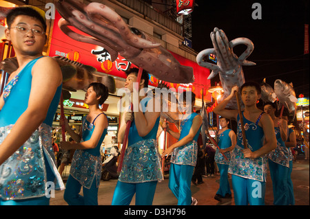 Ragazzi che trasportano sovradimensionare i frutti di mare durante una parata di Keelung, Taiwan Foto Stock