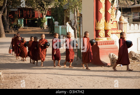 I monaci di Bagan raccogliendo elemosine al sorgere del sole Foto Stock