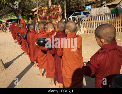 I monaci di Bagan raccogliendo elemosine al sorgere del sole Foto Stock