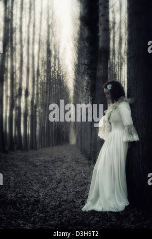 Una donna in una foresta scura Foto Stock