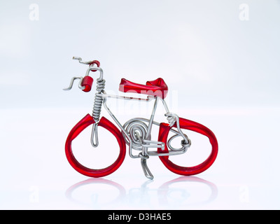 Un rosso di biciclette in miniatura isolati su sfondo bianco Foto Stock